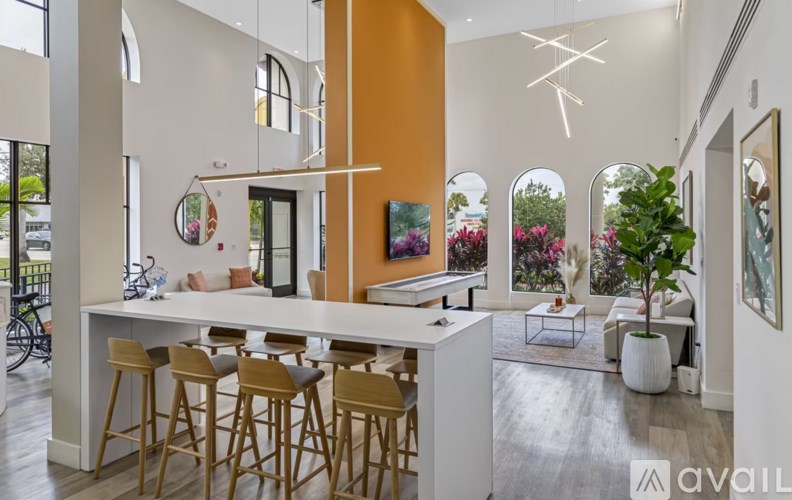 A modern kitchen with a white island and wooden bar stools.