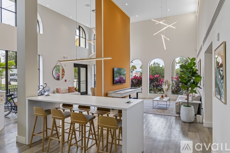 A modern kitchen with a white countertop and wooden bar stools.