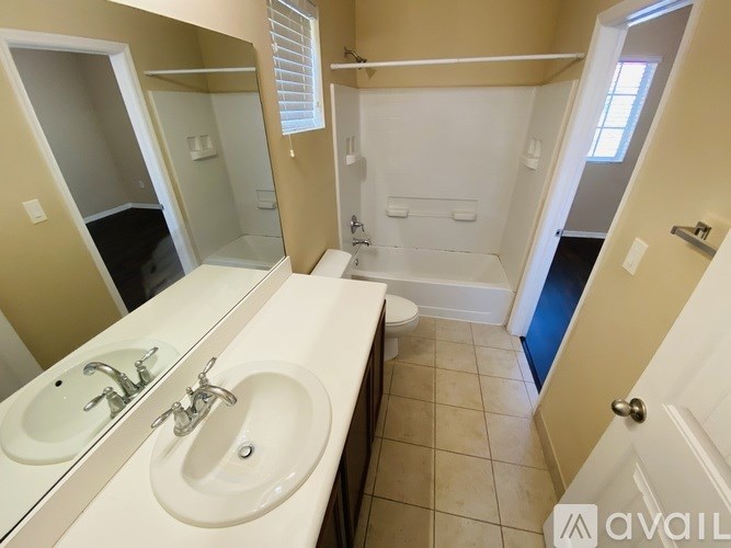A bathroom with a sink, mirror, and bathtub.