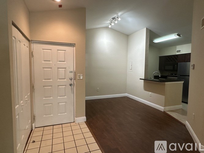 A room with a white door and a brown floor.