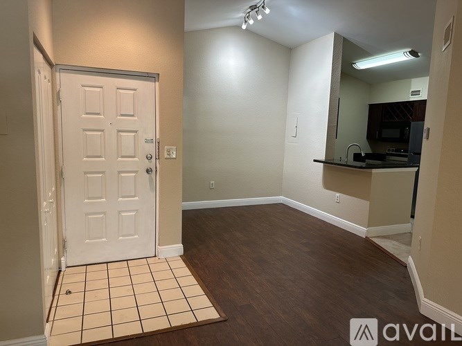 A room with a white door and a tiled floor.
