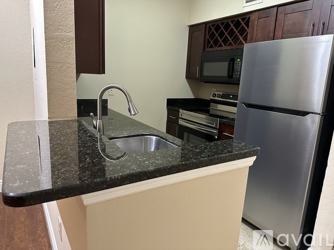 A kitchen with a sink and a refrigerator.