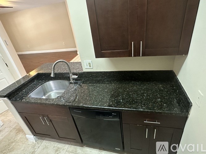 A kitchen with brown cabinets and a black granite countertop.