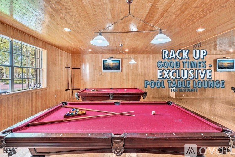 A pool table lounge for residents with a red pool table in the center.