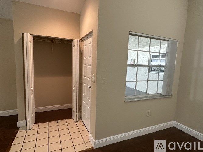 A room with a tiled floor and a window with a view of a building outside.