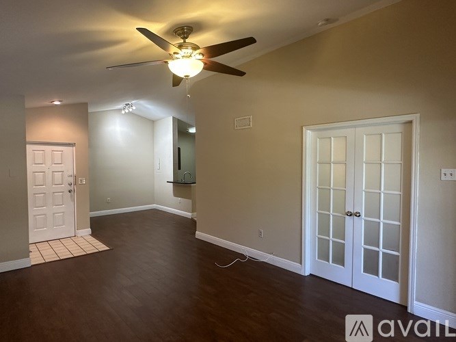 A room with a ceiling fan and a door.