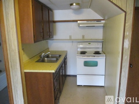 A small kitchen with a white stove and sink.