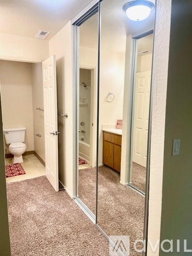 A bathroom with a toilet, sink, and mirror.
