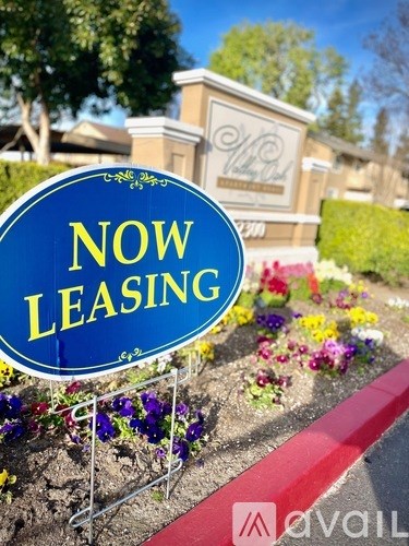 A blue sign with the words "NOW LEASING" in yellow letters.