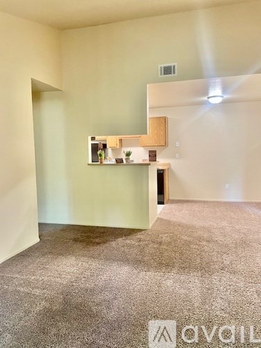 A room with a carpeted floor and a white wall with a shelf on it.