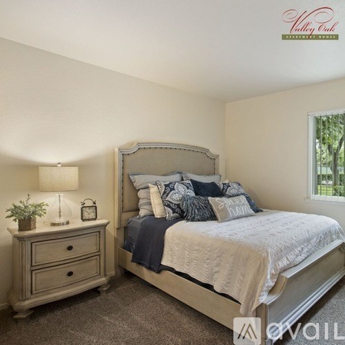 A bedroom with a bed, nightstand, and window.