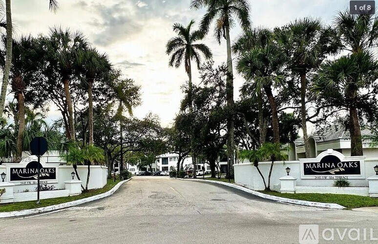 A street view of a residential area with the name "Marina Oaks" on the signage.