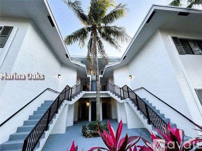 A white building with a staircase leading to the entrance.