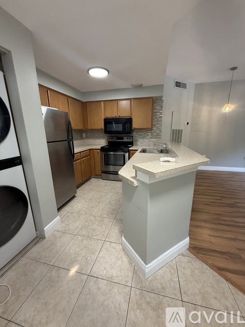 A kitchen with a refrigerator, oven, and microwave.