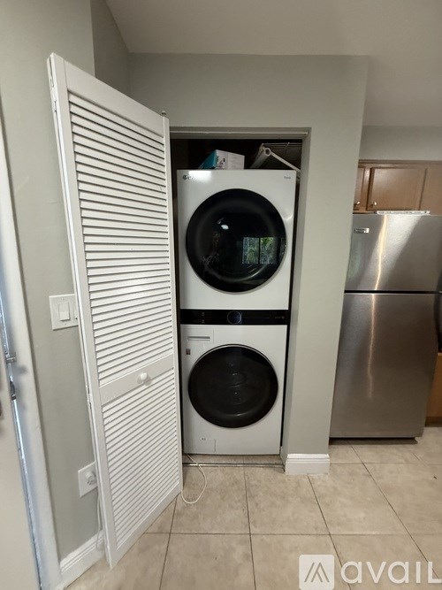 A white washing machine and dryer in a small laundry room.