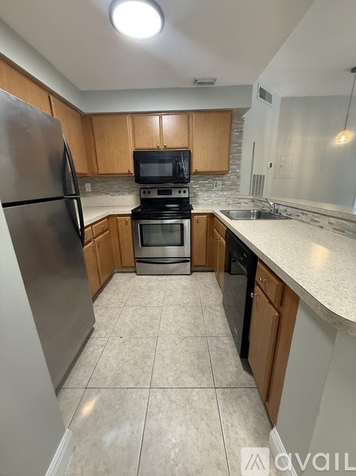 A kitchen with a refrigerator, oven, and microwave.