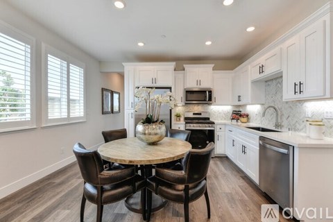 A modern kitchen with a round table and chairs.