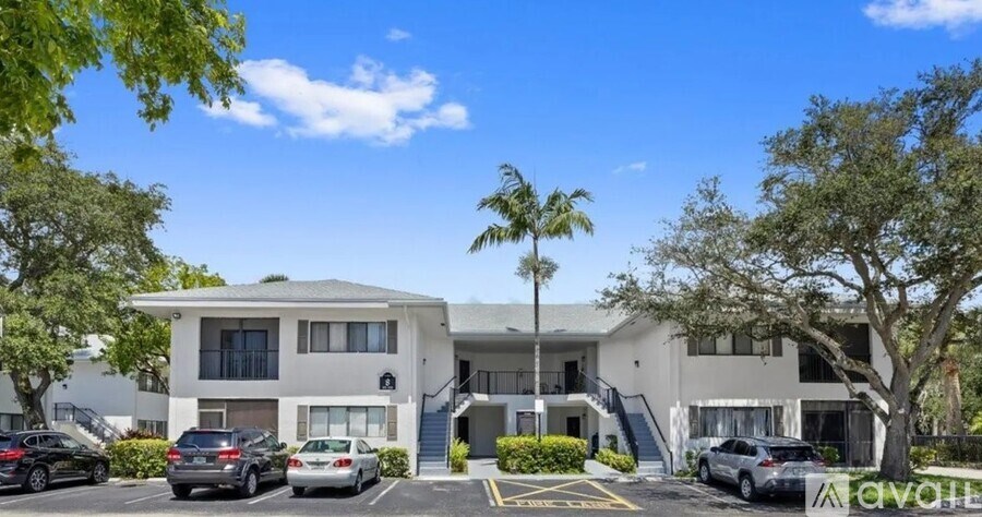 A modern apartment building with cars parked in front.