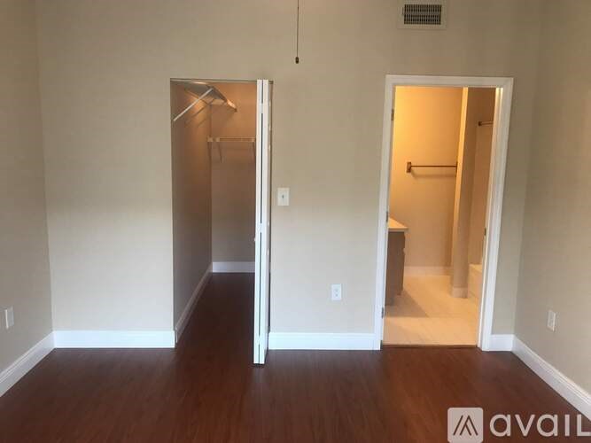 A room with a wooden floor and two open doors.