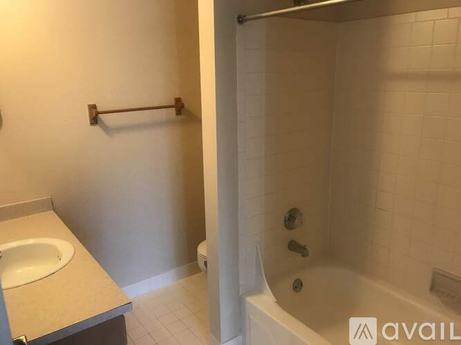A bathroom with a white tub and a white sink.