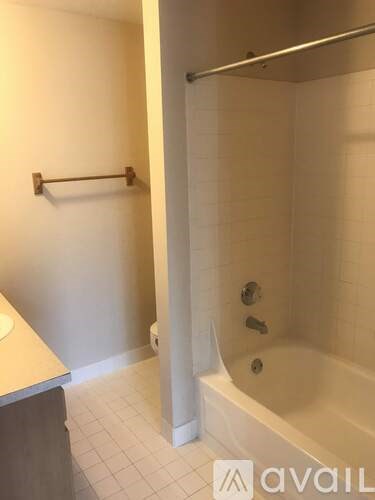 A bathroom with a tub, toilet, and sink.