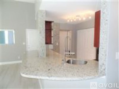 A bathroom with a marble countertop and a shower area.