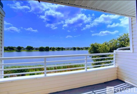 A balcony overlooks a body of water with trees in the distance.