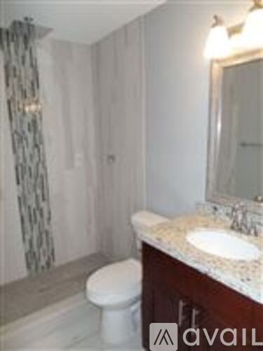 A bathroom with a toilet, sink and shower.