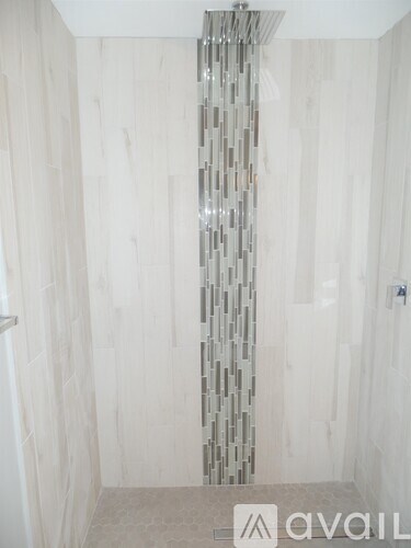 A bathroom with a shower curtain and a beige floor.