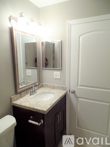 A bathroom with a sink, mirror, and toilet.