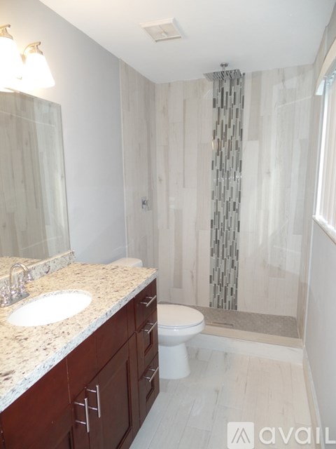 A bathroom with a sink, toilet, and shower.