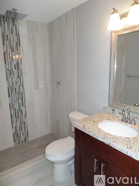 A bathroom with a toilet, sink, and shower.