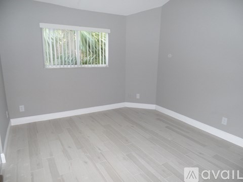 A room with a window and wooden flooring.