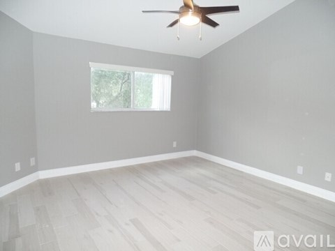 A room with a ceiling fan and a window.