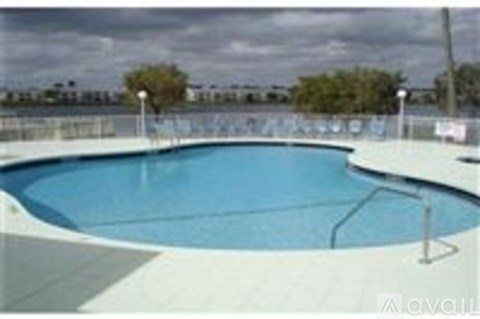 A large outdoor swimming pool with a white fence around it.