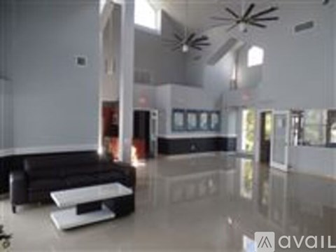 A black couch with a white table in front of it.