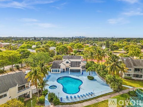 A large house with a pool surrounded by palm trees.