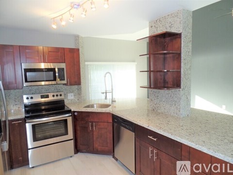 A kitchen with wooden cabinets and granite countertops.