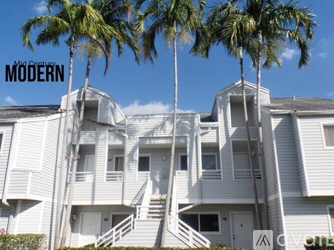 A modern building with palm trees in front.