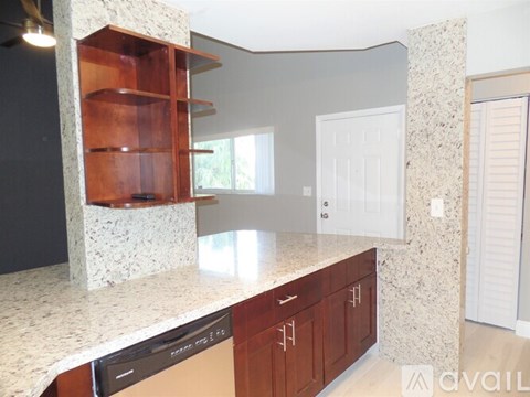 A kitchen with granite countertops and wooden cabinets.