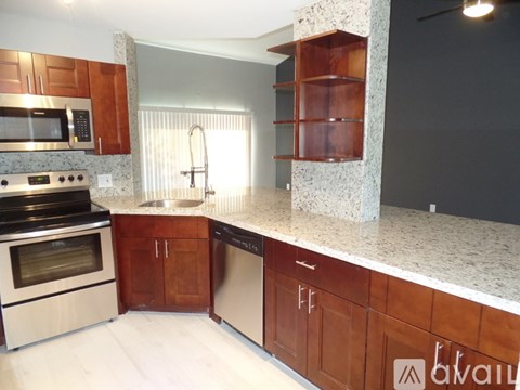 A kitchen with wooden cabinets and a granite countertop.