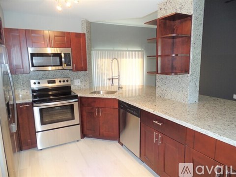 A kitchen with wooden cabinets and granite countertops.