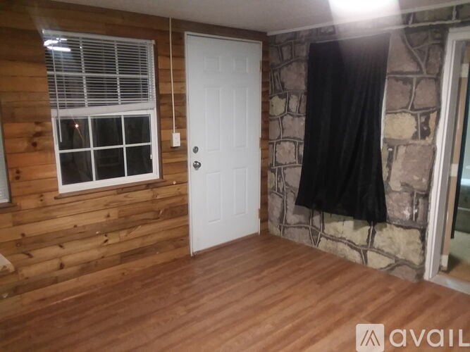 A room with wooden walls and a white door.