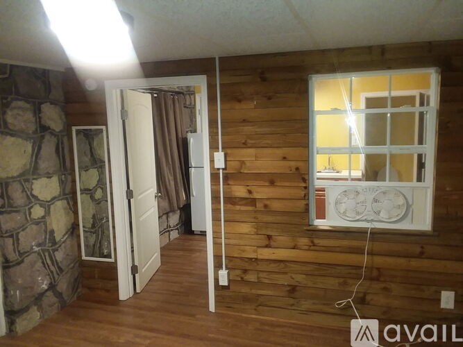A room with wooden walls and a stone column.