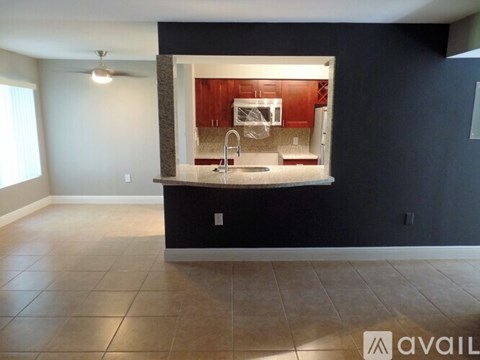 A kitchen with dark walls and a tiled floor is available for rent.