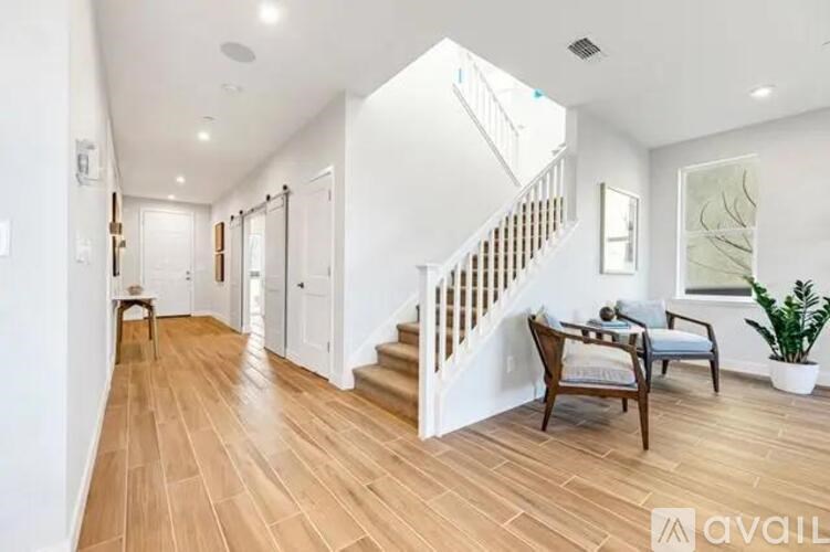 A spacious hallway with wooden floors and a staircase.