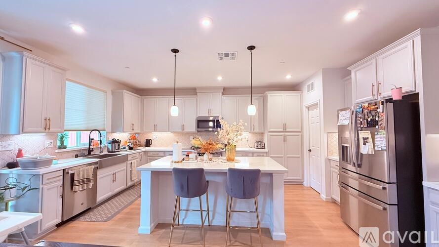 A modern kitchen with a center island and stainless steel appliances.