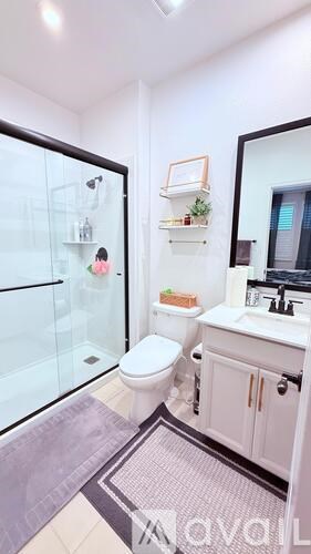 A bathroom with a toilet, sink, and a mirror.