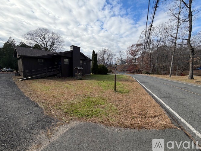 A black house is situated on the side of a road.
