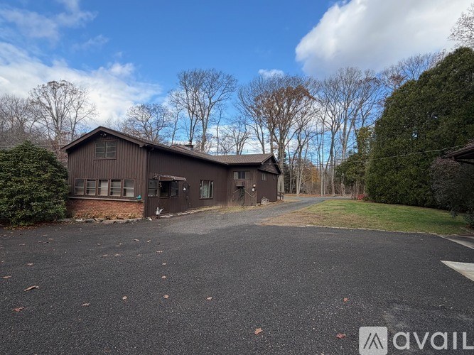 A large brown building with a driveway in front of it.